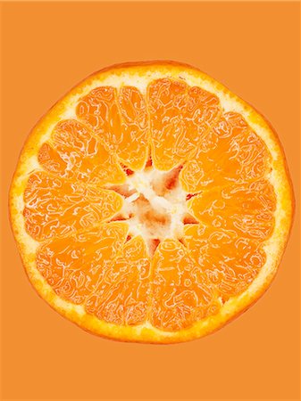 simsearch:700-00015318,k - A slice of mandarin on an orange surface, close-up Photographie de stock - Premium Libres de Droits, Code: 659-08940527