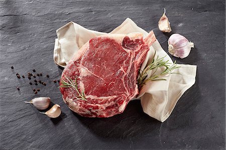 A raw beef rib, garlic, rosemary and peppercorns Stock Photo - Premium Royalty-Free, Code: 659-09124181