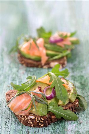 Wholegrain bread topped with avocado slices, salmon and rocket Stock Photo - Premium Royalty-Free, Code: 659-09125299