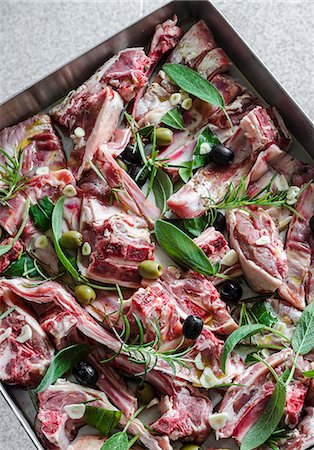 simsearch:659-08147216,k - Pieces of raw lamb with garlic, olives, sage, rosemary and bay leaves on a baking tray Stock Photo - Premium Royalty-Free, Code: 659-09125651