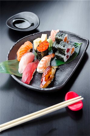 simsearch:659-07610354,k - Japanese fresh mixed sushi platter with salmon, tuna, yellowtail, shrimp nigiri, salmon maki, tuna maki on a black plate and black table Stock Photo - Premium Royalty-Free, Code: 659-09125785
