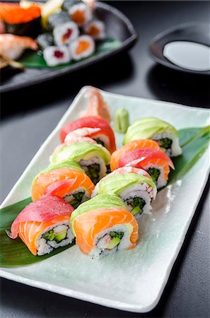 Japanese platter of rainbow rolls maki, inside out seaweed and rice roll filled with cucumber, mayonnaise, avocado, crub stick topped with fresh salmon, tuna, avocado and prawn Stock Photo - Premium Royalty-Free, Code: 659-09125888