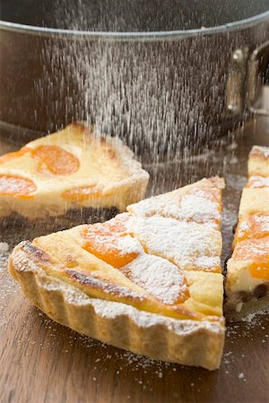 Sprinkling apricot tart with icing sugar Stock Photo - Premium Royalty-Free, Code: 659-01845652