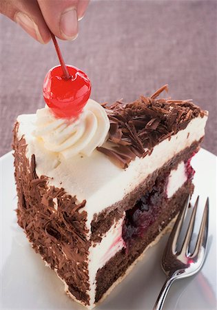 simsearch:659-01848790,k - Decorating a piece of Black Forest gateau with cherry Stock Photo - Premium Royalty-Free, Code: 659-01846280