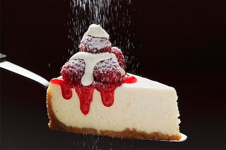 Slice of cheesecake with raspberries, cream, icing sugar on server Stock Photo - Premium Royalty-Free, Code: 659-01857944