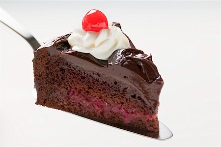 simsearch:659-01848790,k - Slice of chocolate cake with cream & cherry on cake server Stock Photo - Premium Royalty-Free, Code: 659-01857954
