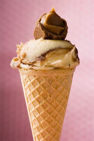 Caramel ice cream in wafer cone against pink background Stock Photo - Premium Royalty-Free, Code: 659-01850221