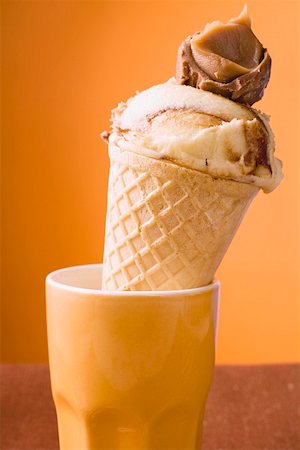 Caramel ice cream in wafer cone in orange beaker Stock Photo - Premium Royalty-Free, Code: 659-01850223