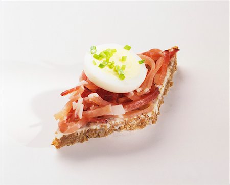 Canapé: strips of bacon & slice of egg on wholegrain bread Stock Photo - Premium Royalty-Free, Code: 659-01850526