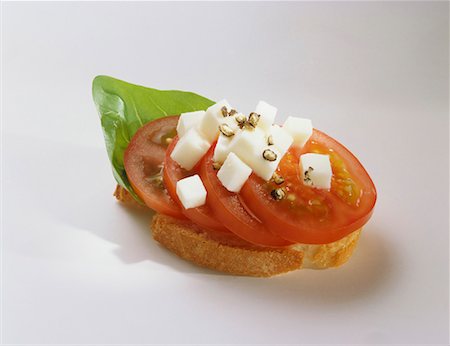 Canapé: tomato, mozzarella and basil on slice of baguette Stock Photo - Premium Royalty-Free, Code: 659-01850528