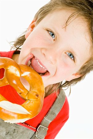 Boy biting into a pretzel Stock Photo - Premium Royalty-Free, Code: 659-01850973