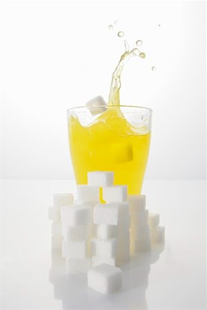 Orangeade with sugar cubes, splashing out of glass Stock Photo - Premium Royalty-Free, Code: 659-01851477