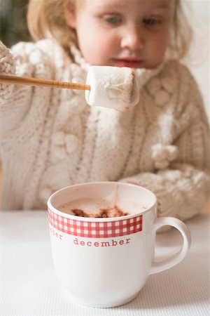 Small girl dipping marshmallow in cocoa Stock Photo - Premium Royalty-Free, Code: 659-01865358