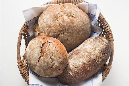 rye bread - Three rustic loaves of bread in a bread basket Stock Photo - Premium Royalty-Free, Code: 659-01866609