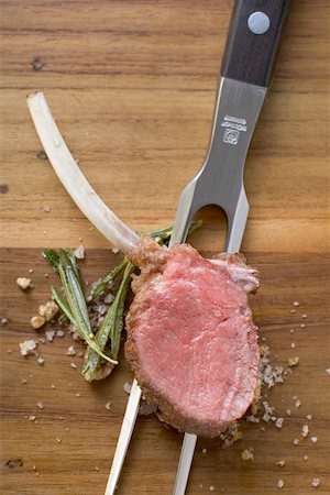 simsearch:659-08148038,k - Lamb chop with rosemary and salt on meat fork Stock Photo - Premium Royalty-Free, Code: 659-01867437