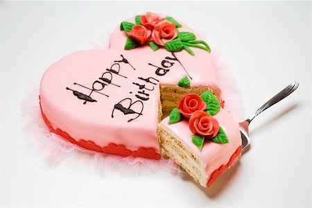 Pink heart-shaped birthday cake with piece on server Stock Photo - Premium Royalty-Free, Code: 659-01860634