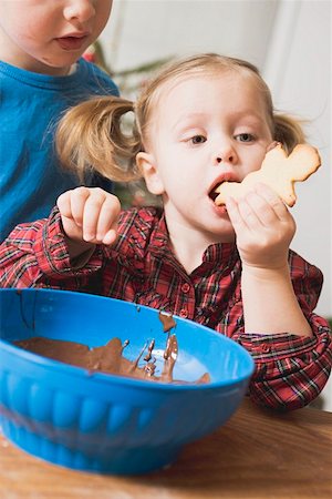 Girl eating Christmas biscuit with chocolate icing Stock Photo - Premium Royalty-Free, Code: 659-01861862