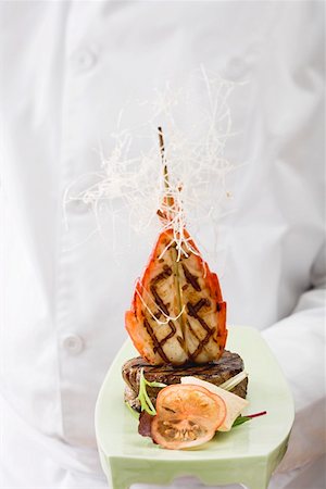 Chef holding Surf & Turf (beef steak with prawn) on platter Stock Photo - Premium Royalty-Free, Code: 659-01862825