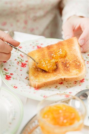 Spreading orange marmalade on toast Stock Photo - Premium Royalty-Free, Code: 659-01862879