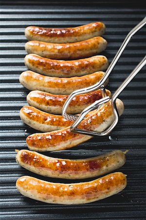 Grilled sausages from above with tongs Stock Photo - Premium Royalty-Free, Code: 659-01863050