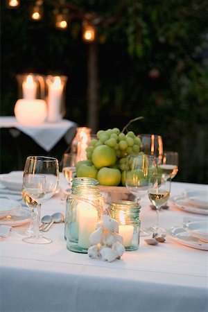 Bowl of fruit and windlights on table laid in garden Stock Photo - Premium Royalty-Free, Code: 659-02212653