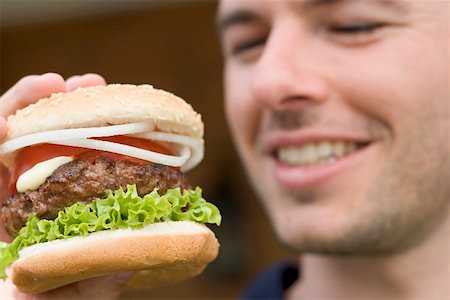 Man holding large hamburger Stock Photo - Premium Royalty-Free, Code: 659-02212703