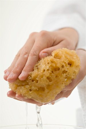 Hands squeezing out wet sponge Foto de stock - Sin royalties Premium, Código: 659-02212938