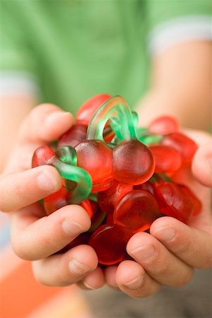 Child's hands holding cherry jelly sweets Stock Photo - Premium Royalty-Free, Code: 659-02213073