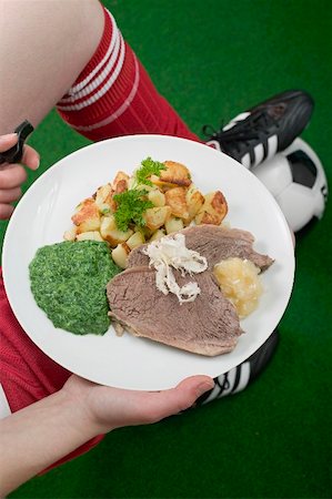 Footballer holding plate of boiled beef with accompaniments Stock Photo - Premium Royalty-Free, Code: 659-02213088
