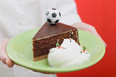 Person holding piece of Sacher torte with cream & football Stock Photo - Premium Royalty-Free, Code: 659-02213096