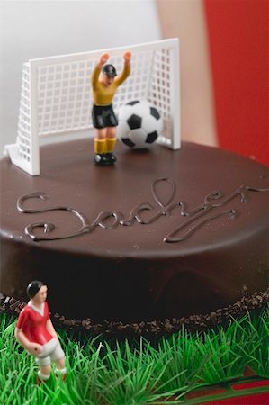 Woman holding Sacher torte with football figures Stock Photo - Premium Royalty-Free, Code: 659-02213093