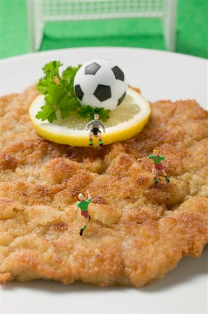 Wiener schnitzel (veal escalope) with football & football figures Stock Photo - Premium Royalty-Free, Code: 659-02213127