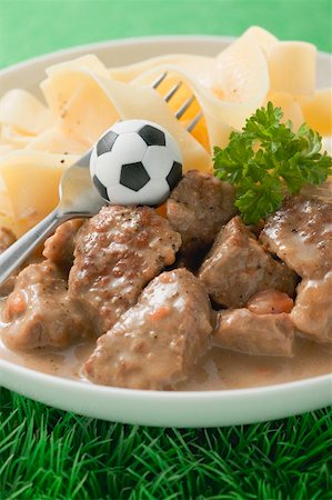 simsearch:659-02213122,k - Zürcher Geschnetzeltes (veal dish) with pasta, football & fork Stock Photo - Premium Royalty-Free, Code: 659-02213139