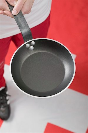 Footballer on Swiss flag holding frying pan Stock Photo - Premium Royalty-Free, Code: 659-02213130