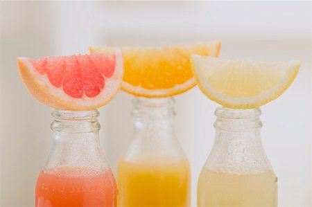 simsearch:659-06495307,k - Three fruit juices in bottles with wedges of fresh fruit Stock Photo - Premium Royalty-Free, Code: 659-02213304
