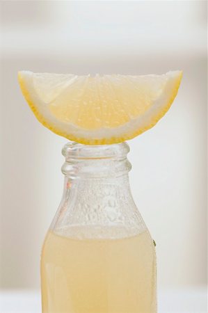 single lemon - Lemon juice in bottle with fresh lemon wedge Stock Photo - Premium Royalty-Free, Code: 659-02213307