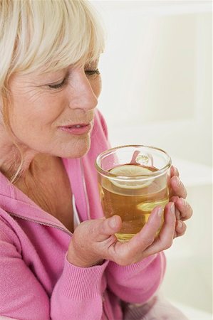 Woman savouring the scent of lemon tea Stock Photo - Premium Royalty-Free, Code: 659-02213411