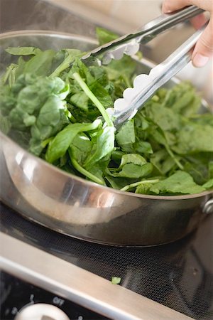 Turning spinach in pan with tongs Stock Photo - Premium Royalty-Free, Code: 659-02213955