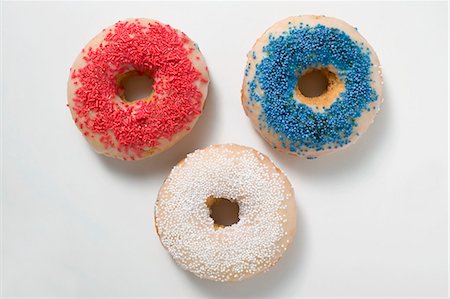 sprinkles - Three doughnuts with sprinkles (red, blue, white) Stock Photo - Premium Royalty-Free, Code: 659-03524344
