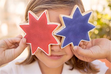 fourth of july - Small girl holding two star cookies in front of her eyes Stock Photo - Premium Royalty-Free, Code: 659-03524440