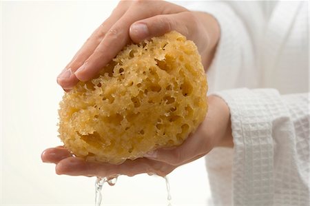 Hands squeezing out wet bath sponge Foto de stock - Sin royalties Premium, Código: 659-03524635
