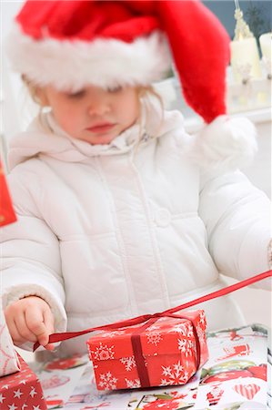 simsearch:659-03526649,k - Small girl in Father Christmas hat opening Christmas parcel Stock Photo - Premium Royalty-Free, Code: 659-03524969