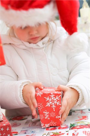 simsearch:659-03526649,k - Small girl in Father Christmas hat opening Christmas parcel Stock Photo - Premium Royalty-Free, Code: 659-03524970
