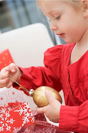 Small girl holding gold Christmas bauble Foto de stock - Sin royalties Premium, Código: 659-03524981