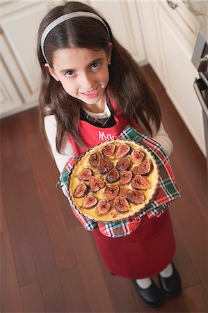 Girl holding freshly-baked fig tart (overhead view) Stock Photo - Premium Royalty-Free, Code: 659-03525016
