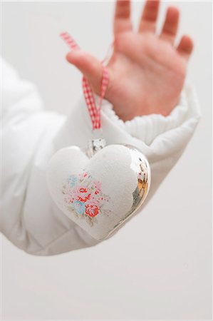 Child's hand holding Christmas tree ornament Stock Photo - Premium Royalty-Free, Code: 659-03525453