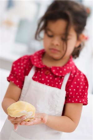 Small girl forming dough into a ball Foto de stock - Sin royalties Premium, Código: 659-03525761
