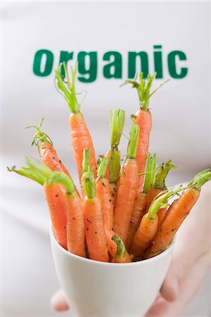 Woman holding fresh carrots in basin Stock Photo - Premium Royalty-Free, Code: 659-03526548