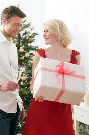 simsearch:659-03526649,k - Woman holding large Christmas parcel, man holding glass of wine Stock Photo - Premium Royalty-Free, Code: 659-03526669