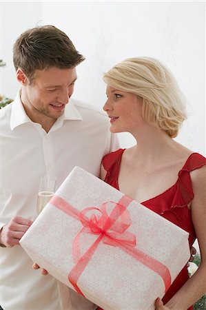 simsearch:659-03526649,k - Woman holding large Christmas parcel, man holding glass of wine Stock Photo - Premium Royalty-Free, Code: 659-03526670